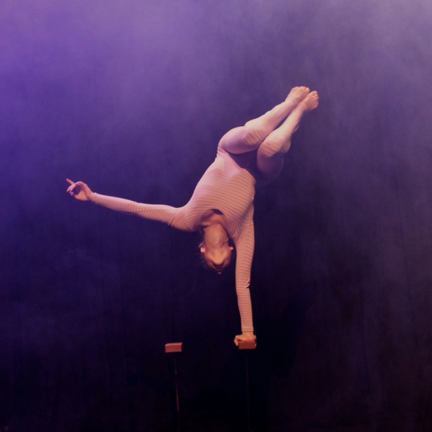 Circus Helsinki Henkilö seisoo yhdellä kädellä sirkusesityksessä.