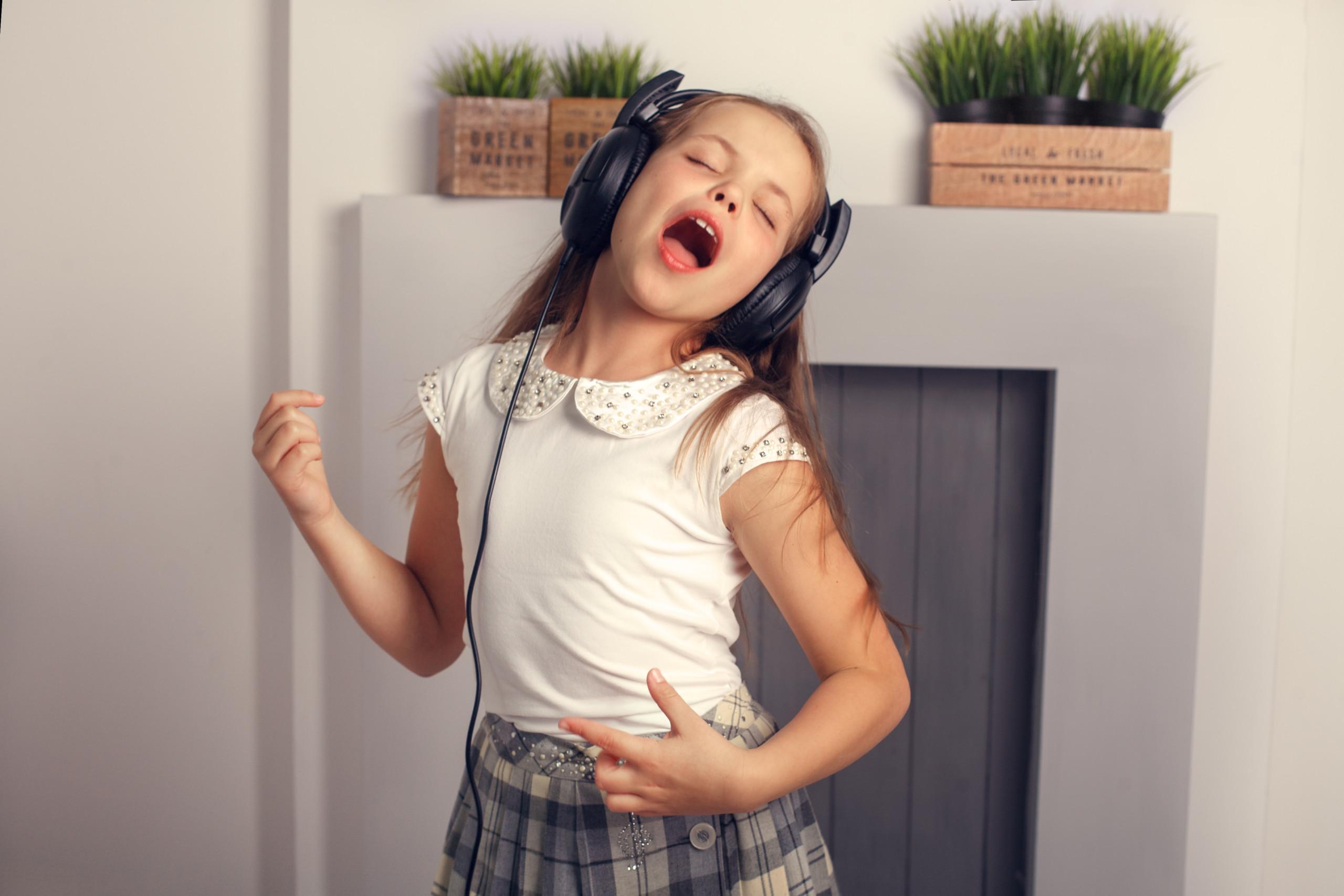 child rocker singing and dancing with headphones. The concept of